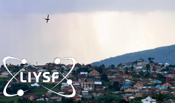 An aeroplane flying through the sky over a village.